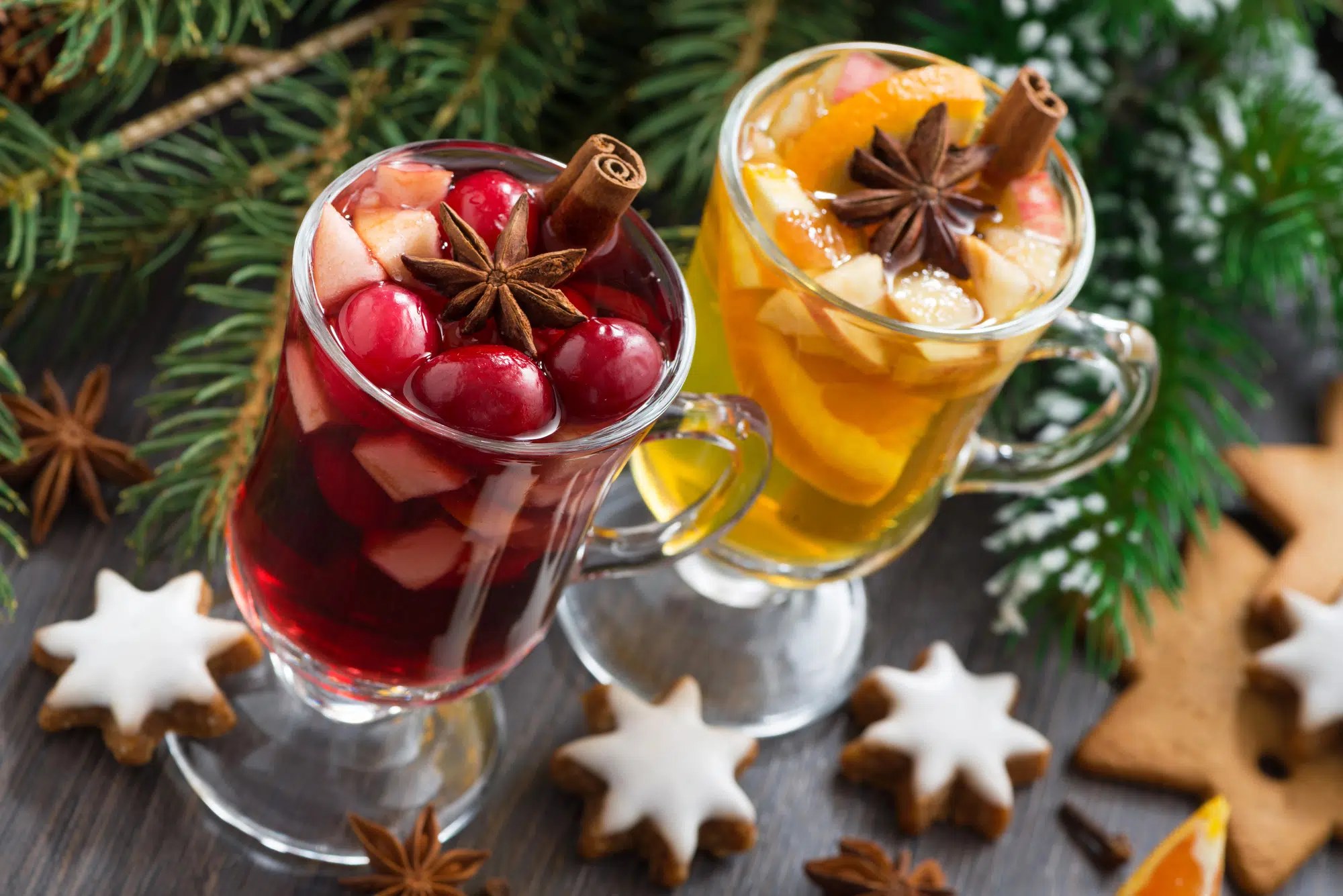 Cocktail de Noël servi dans un verre à pied, décoré d'une écorce d'orange et d'un bâton de cannelle