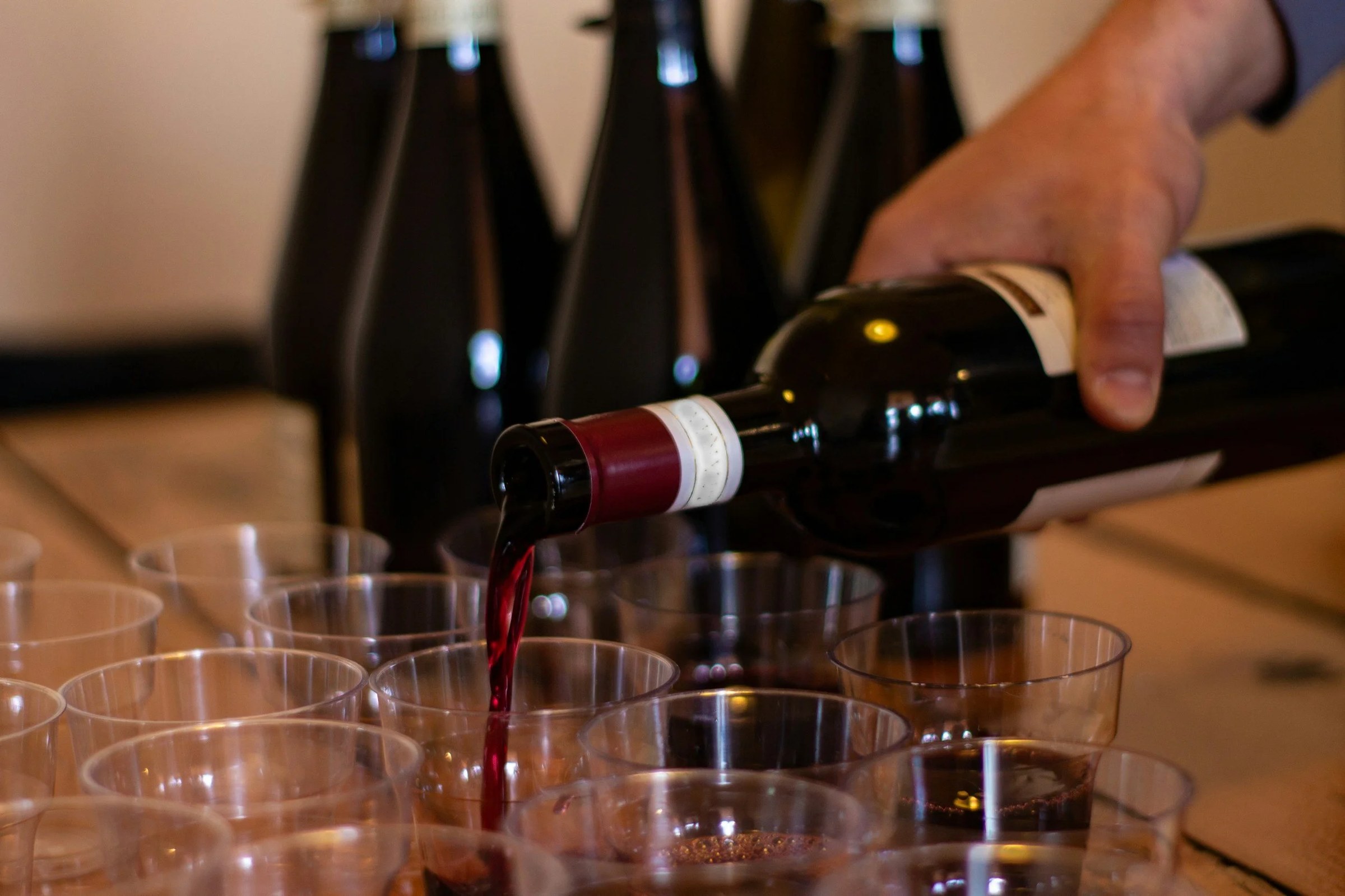 Bouteille de vin de 75 cl entourée de verres servis sur une table, pour illustrer le nombre de verres par bouteille